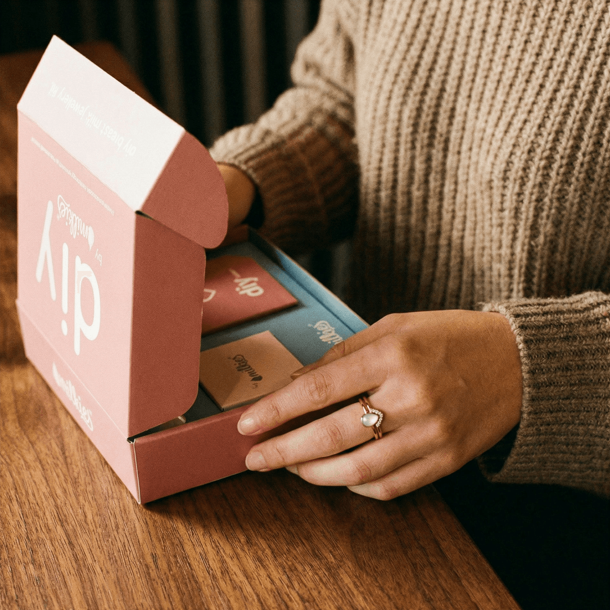 Osoba otwiera zestaw DIY by MILKIES, pokazując dlaczego warto wybrać domowy kit do wykonania pierścionki z mleka matki oraz innych spersonalizowanych pamiątek z mleka w zaciszu domu.